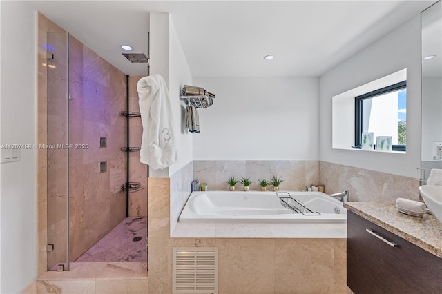 bathroom with vanity, visible vents, a bath, and a stall shower