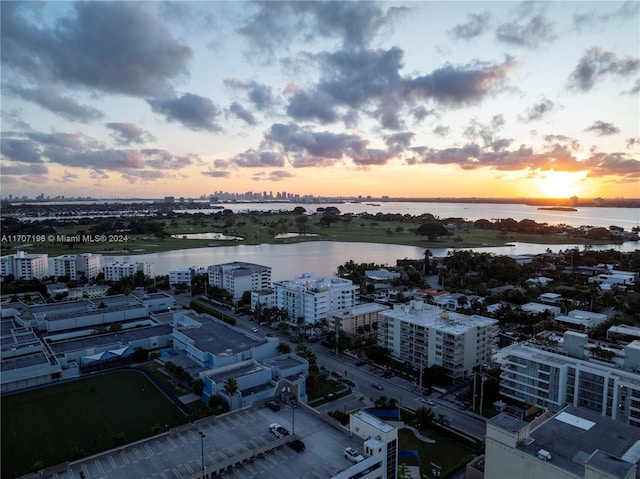 aerial view at dusk featuring a water view