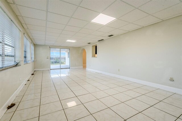 tiled spare room featuring a paneled ceiling