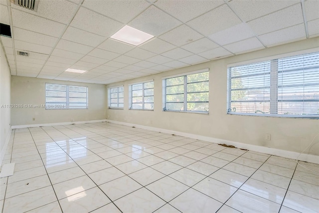 tiled spare room with a paneled ceiling