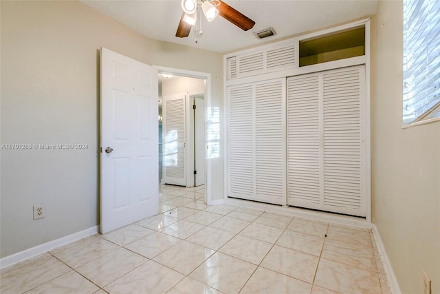 unfurnished bedroom featuring light tile patterned flooring, a closet, and ceiling fan