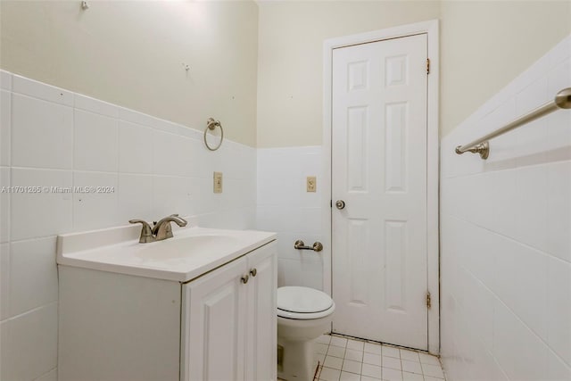 bathroom featuring tile patterned floors, vanity, tile walls, and toilet