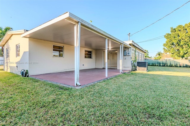 back of house with a lawn, a patio, and central AC