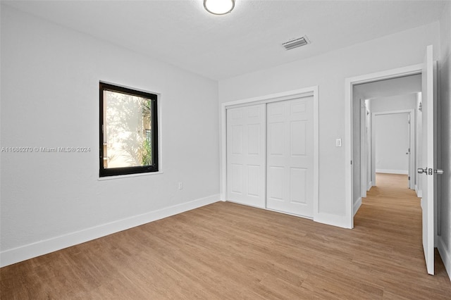 unfurnished bedroom featuring light hardwood / wood-style floors and a closet