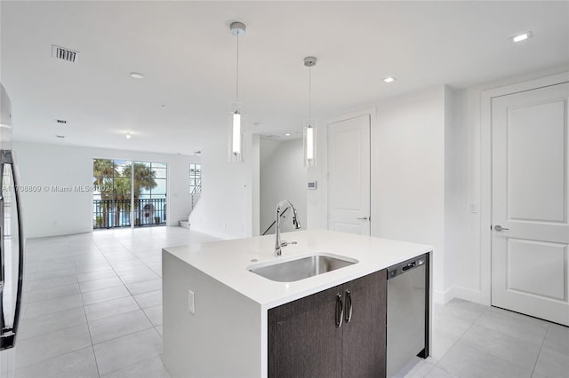 kitchen featuring dark brown cabinetry, dishwasher, sink, hanging light fixtures, and a center island with sink