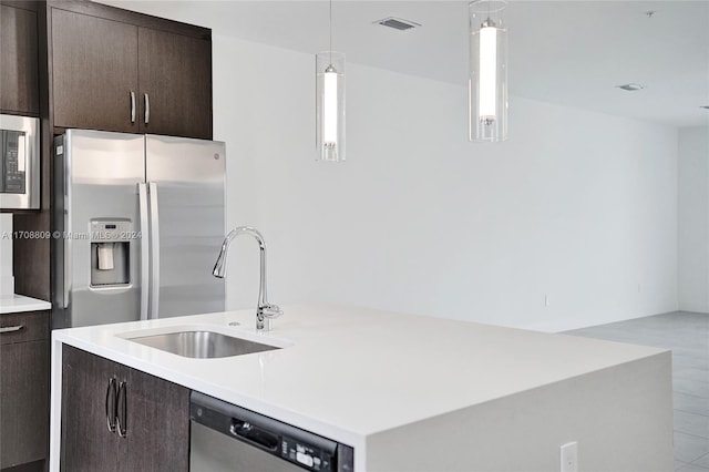 kitchen with decorative light fixtures, dark brown cabinetry, sink, and appliances with stainless steel finishes