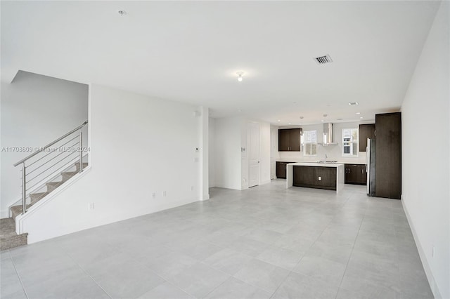 unfurnished living room with light tile patterned floors and sink