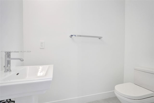 bathroom with tile patterned flooring, toilet, and sink