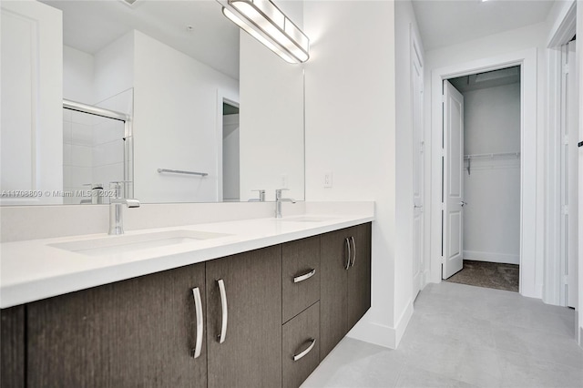 bathroom featuring tile patterned floors, vanity, and a shower with door