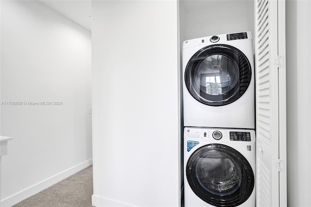 clothes washing area featuring stacked washer / drying machine and light colored carpet