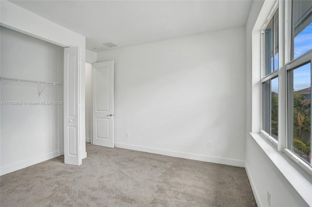 unfurnished bedroom featuring multiple windows and light colored carpet