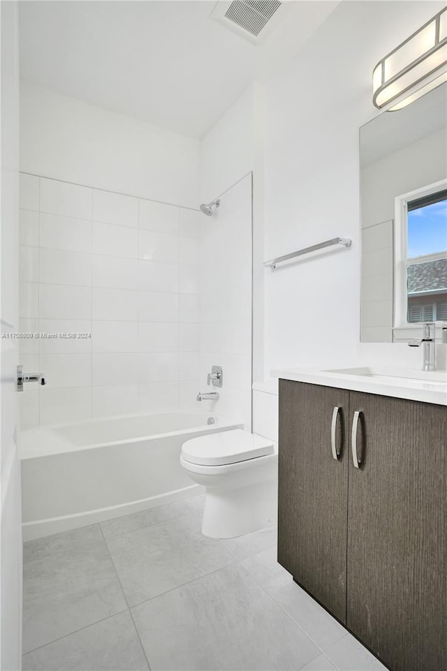 full bathroom featuring tile patterned floors, vanity, toilet, and tiled shower / bath