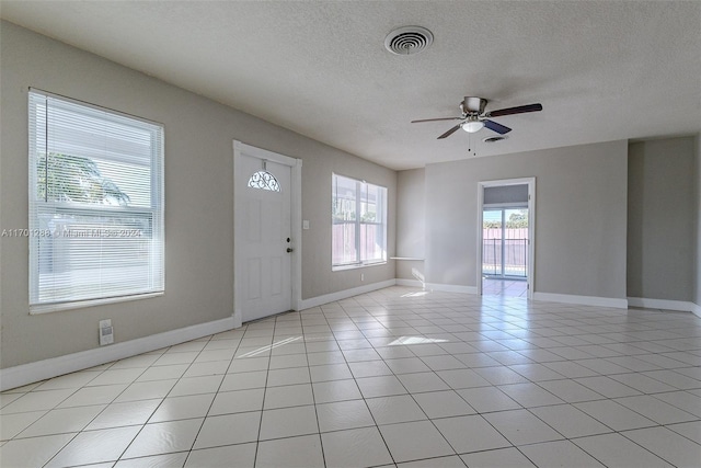 foyer with ceiling fan, light tile patterned floors, and a textured ceiling