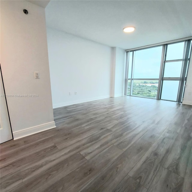 spare room featuring dark hardwood / wood-style floors and a wall of windows