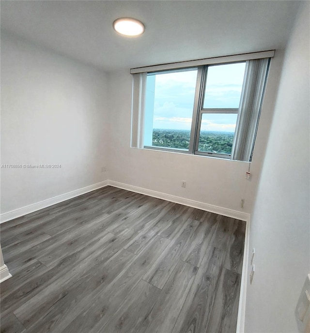 unfurnished room with dark hardwood / wood-style flooring