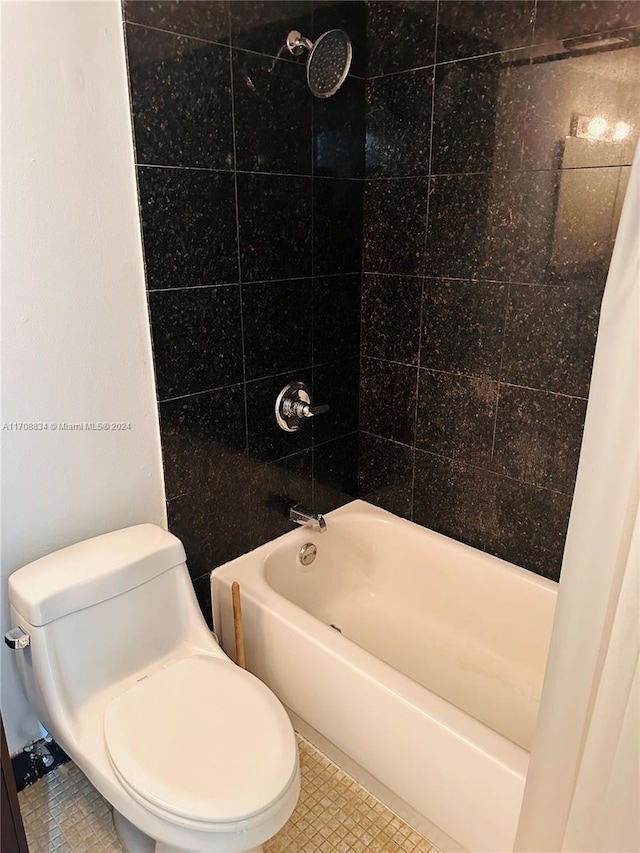 bathroom featuring tiled shower / bath combo and toilet