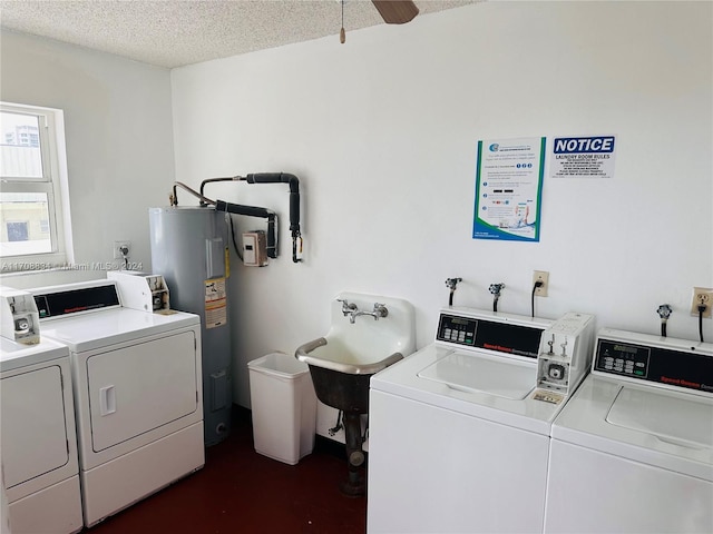 washroom featuring a textured ceiling, ceiling fan, sink, water heater, and separate washer and dryer