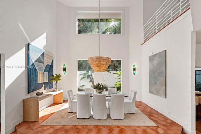 dining area featuring a chandelier and a towering ceiling