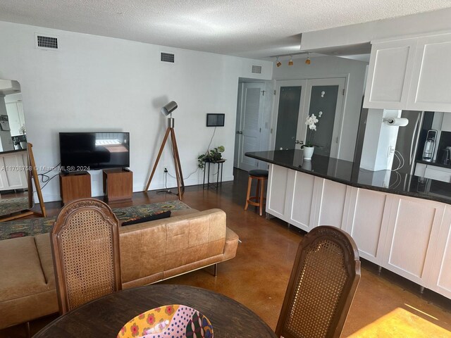 living room featuring french doors and a textured ceiling