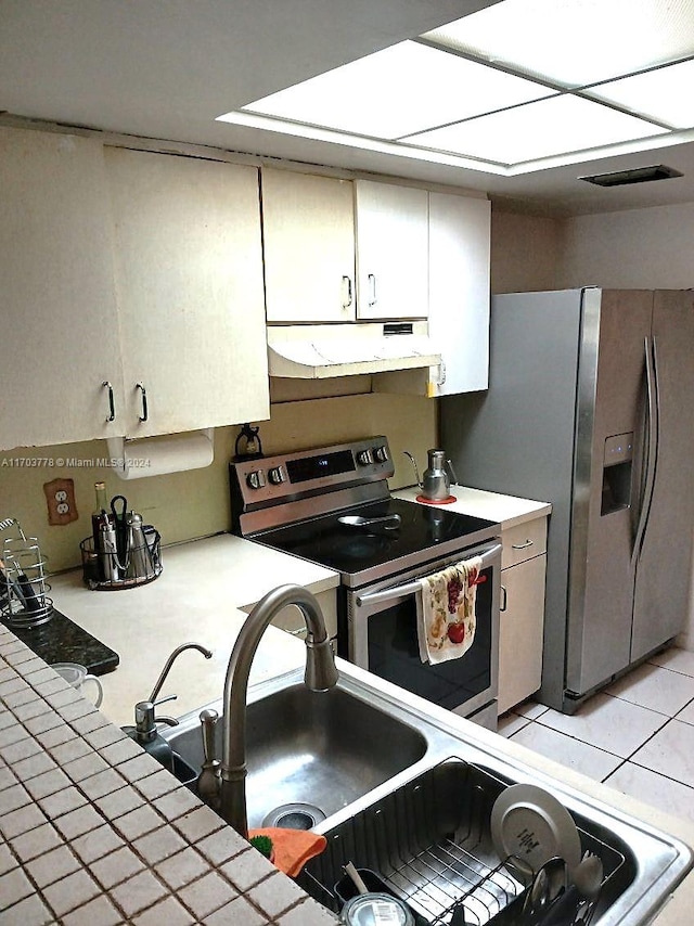 kitchen featuring tile counters, sink, light tile patterned flooring, and stainless steel appliances