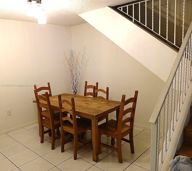 dining room with light tile patterned flooring and a textured ceiling