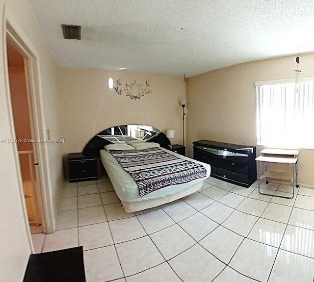 bedroom featuring light tile patterned flooring and a textured ceiling