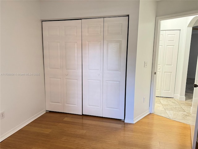 unfurnished bedroom featuring light hardwood / wood-style flooring and a closet