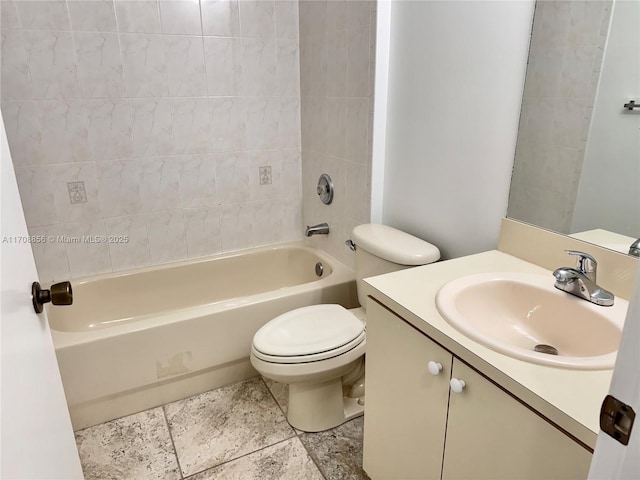 full bathroom featuring vanity, tiled shower / bath, and toilet