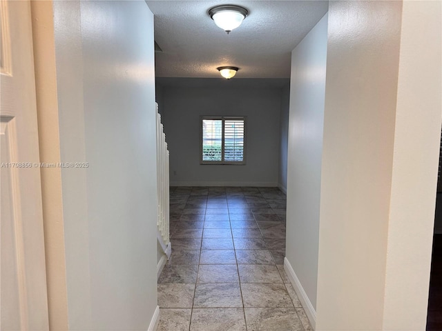 hall featuring a textured ceiling