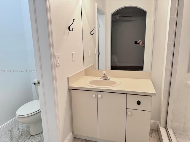 bathroom featuring vanity, toilet, and walk in shower