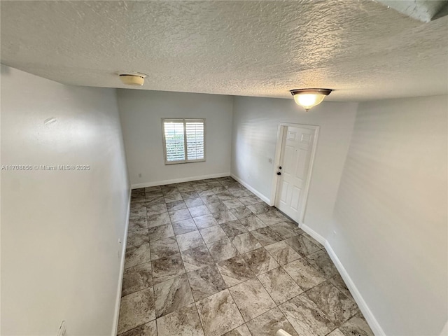 unfurnished room featuring a textured ceiling