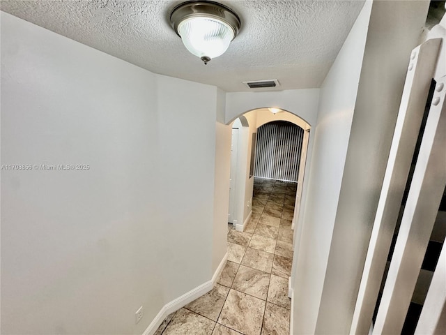 hall with a textured ceiling