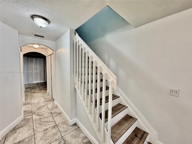 stairway with a textured ceiling