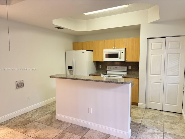 kitchen with tasteful backsplash, white appliances, and a raised ceiling