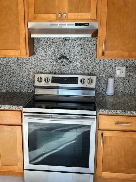 kitchen with ventilation hood, decorative backsplash, stainless steel electric range oven, and dark stone counters