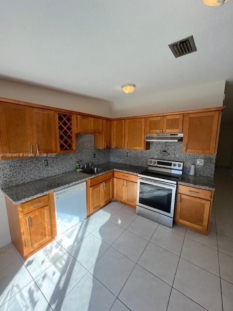 kitchen with stainless steel range with electric stovetop, dark stone counters, white dishwasher, decorative backsplash, and light tile patterned floors