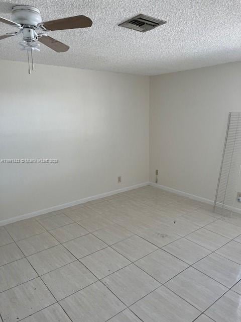 unfurnished room with ceiling fan and a textured ceiling