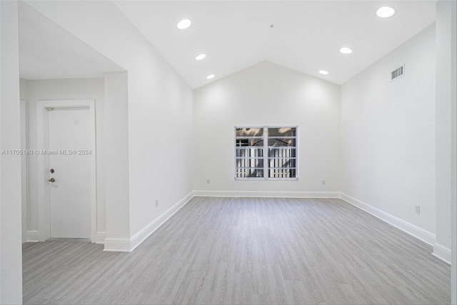 empty room featuring light hardwood / wood-style floors and vaulted ceiling