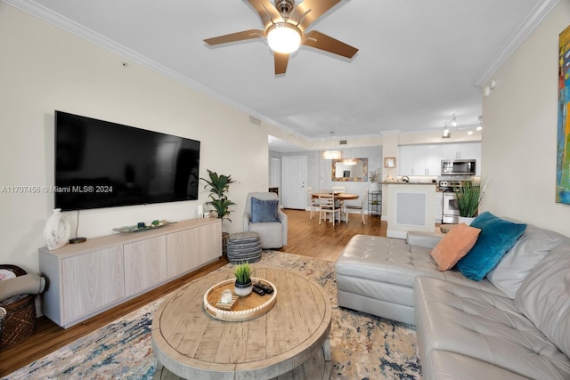 living room with ceiling fan, crown molding, and light hardwood / wood-style flooring