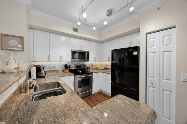 kitchen with backsplash, stainless steel appliances, white cabinetry, and sink