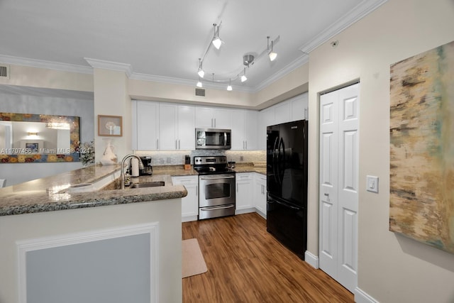 kitchen featuring kitchen peninsula, stainless steel appliances, sink, white cabinets, and hardwood / wood-style floors