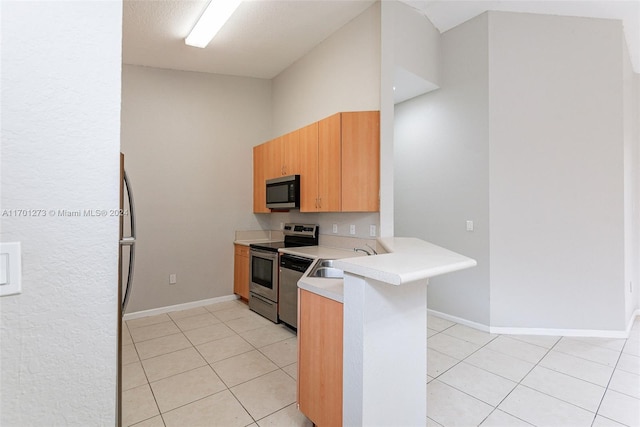 kitchen featuring kitchen peninsula, light tile patterned floors, sink, and appliances with stainless steel finishes