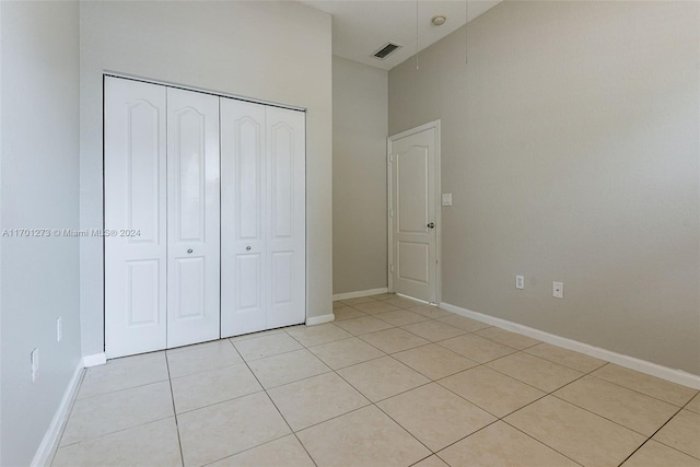 unfurnished bedroom with light tile patterned floors and a closet