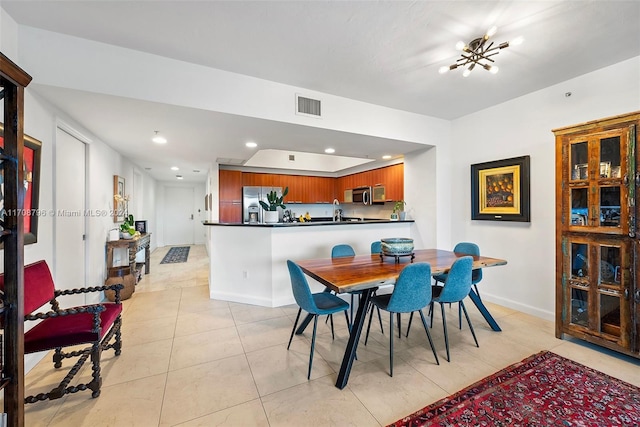 tiled dining space featuring a chandelier