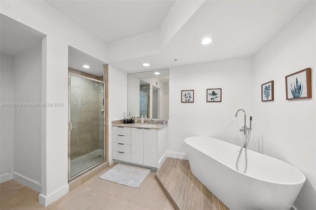 bathroom featuring tile patterned flooring, shower with separate bathtub, and vanity