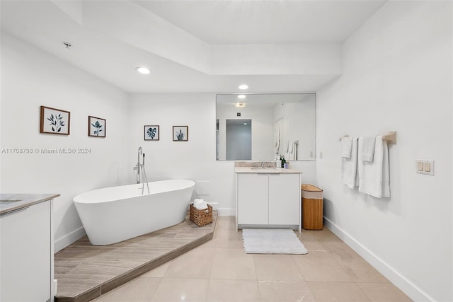 bathroom with a washtub, vanity, and tile patterned floors