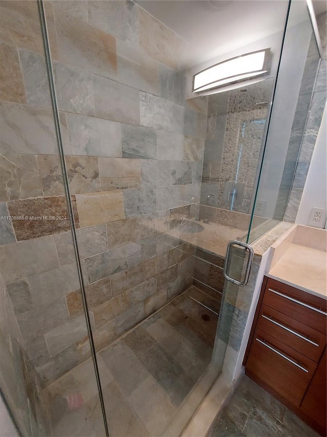 bathroom featuring vanity and a shower with shower door