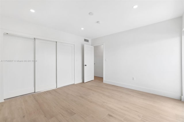 unfurnished bedroom with light hardwood / wood-style floors and a closet