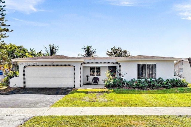 single story home with a garage and a front lawn