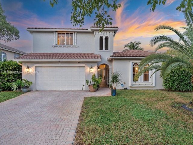 view of front of home featuring a garage and a lawn